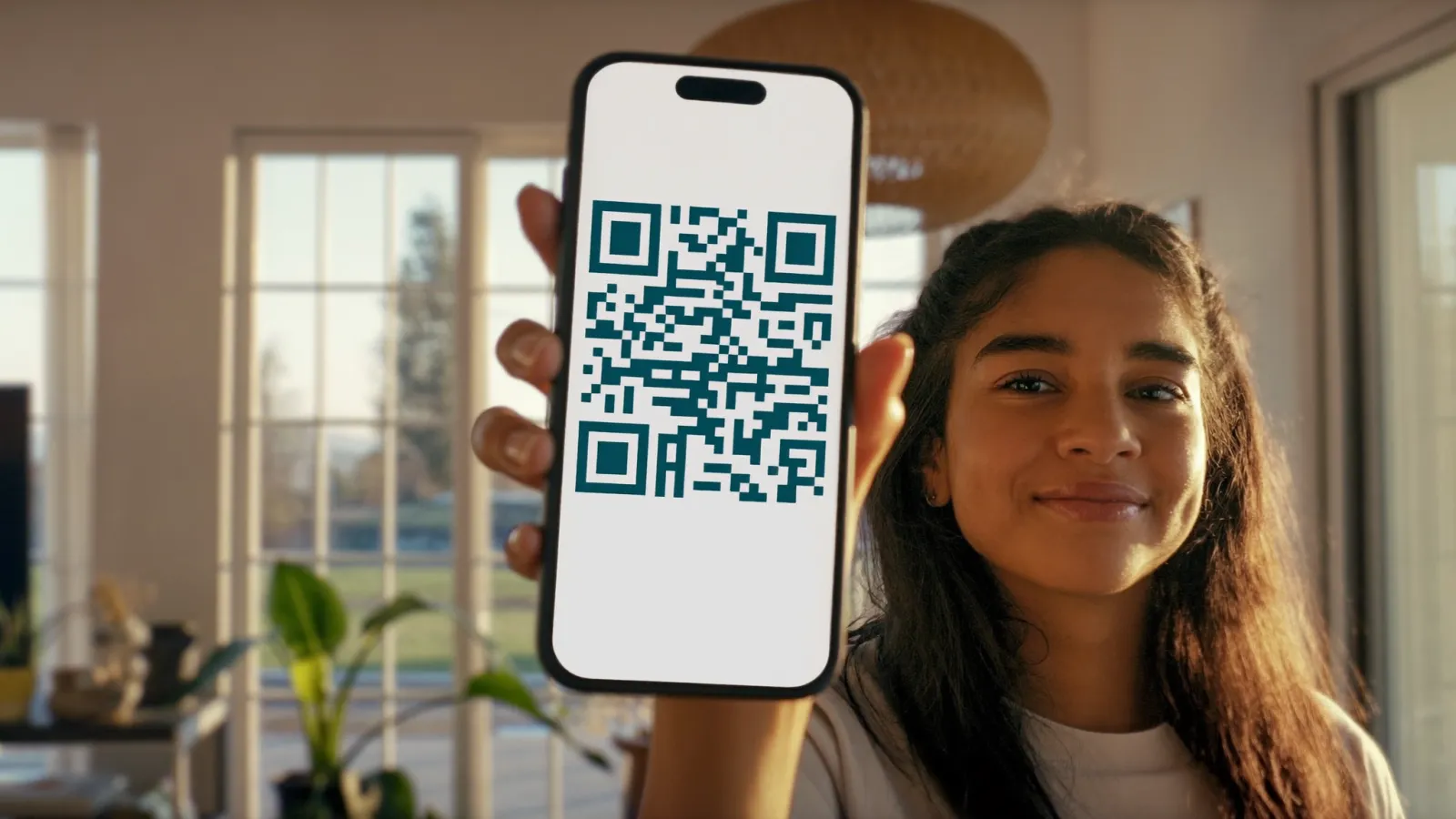 Paciente en casa mostrando su teléfono con una receta digital con código QR